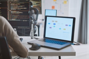 Young adult Asian male, female software developer coding program on desktop computer. Man, woman work from home, remote working, freelance programmer job, smart digital nomad lifestyle concept